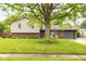Inviting home featuring mature landscaping, a brick facade, and a cozy seating area on the front porch at 1440 Fenwick Ave, Indianapolis, IN 46219