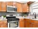 Kitchen area features stainless steel appliances, tile backsplash, and wood cabinets at 1440 Fenwick Ave, Indianapolis, IN 46219