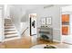 Spacious living room featuring hardwood floors, stairs, access to the kitchen, and stylish decorative elements at 1440 Fenwick Ave, Indianapolis, IN 46219