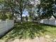 Large grassy backyard with a wood fence and mature shade trees at 1440 Sycamore St, Columbus, IN 47201