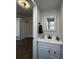 Bathroom with a large vanity, mirror, updated fixtures, and bedroom view at 1440 Sycamore St, Columbus, IN 47201