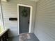 Welcoming front door with wreath and 'Home Sweet Home' doormat on front porch at 1440 Sycamore St, Columbus, IN 47201