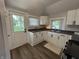 Bright kitchen featuring white cabinets, dark counters, stainless faucet, and natural light at 1440 Sycamore St, Columbus, IN 47201