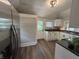 Charming kitchen with white cabinets, dark countertops, an exterior door and stainless refrigerator at 1440 Sycamore St, Columbus, IN 47201