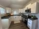 Bright kitchen with white cabinetry, stainless steel appliances, and dark countertops at 1440 Sycamore St, Columbus, IN 47201