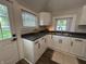 Efficient kitchen with white cabinets, dark countertops, and a view to the outdoors at 1440 Sycamore St, Columbus, IN 47201