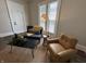 Cozy living area featuring a stylish chair, sofa and ample natural light from the large windows at 1440 Sycamore St, Columbus, IN 47201