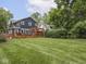 Spacious backyard featuring lush green grass, large trees and a wooden deck at 150 E 46Th St, Indianapolis, IN 46205