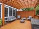 Backyard deck under a wooden pergola with string lights, stylish seating, and a fire pit for outdoor entertaining at 150 E 46Th St, Indianapolis, IN 46205