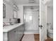 Beautiful bathroom features a walk-in shower, gray vanity with double sinks, and decorative wallpaper at 150 E 46Th St, Indianapolis, IN 46205
