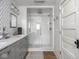 Beautiful bathroom features a walk-in shower with white tiling and gray vanity with double sinks at 150 E 46Th St, Indianapolis, IN 46205