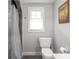 Neutral bathroom with toilet and tiled shower featuring grey shower curtain and hardware at 150 E 46Th St, Indianapolis, IN 46205
