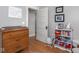 Bedroom with a changing table, wooden floors, wall decor, and a bookshelf filled with toys, creating a delightful space at 150 E 46Th St, Indianapolis, IN 46205