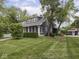 Charming home with dark siding, bright white trim, and a well-manicured lawn at 150 E 46Th St, Indianapolis, IN 46205