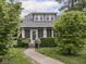 Inviting home with a manicured lawn, pathway, and blossoming trees framing the entrance at 150 E 46Th St, Indianapolis, IN 46205