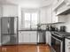 Well-lit kitchen showcasing stainless steel appliances, white cabinets, and wood floors at 150 E 46Th St, Indianapolis, IN 46205