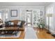 Bright living room featuring a leather sofa, hardwood floors and view of the front porch at 150 E 46Th St, Indianapolis, IN 46205