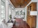 Well-lit sunroom boasts tiled floors, classic furniture, and a charming wooden cabinet at 150 E 46Th St, Indianapolis, IN 46205