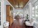 Sunlit sunroom featuring a vintage cabinet, tiled floors, seating, and a cozy dining set at 150 E 46Th St, Indianapolis, IN 46205