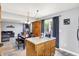 An open-concept dining room with wood table and gray walls adjacent to a kitchen and views of backyard at 15264 Ten Point Dr, Noblesville, IN 46060