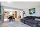 Open-concept living room and dining area featuring plank flooring, a gray sofa, and neutral wall color at 15264 Ten Point Dr, Noblesville, IN 46060