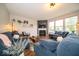 Cozy living room with a fireplace, hardwood floors, and large windows overlooking the yard at 15675 Myland Dr, Noblesville, IN 46062