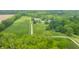 Aerial view of an estate featuring a well-maintained lawn, long driveway, and surrounding trees at 1820 N 1100 E, Sheridan, IN 46069