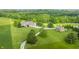 Aerial view showing a charming home with mature trees, driveway, and a separate barn structure at 1820 N 1100 E, Sheridan, IN 46069