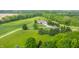 Overhead shot showcasing the home, its well-kept lawn, and the surrounding mature trees at 1820 N 1100 E, Sheridan, IN 46069