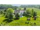 Lush estate featuring a gorgeous in-ground pool, fun playset, and vast green lawns surrounded by dense, mature trees at 1820 N 1100 E, Sheridan, IN 46069