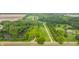 Aerial view of a large property with manicured lawns, pond, mature trees and a long driveway at 1820 N 1100 E, Sheridan, IN 46069