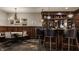 Elegant in-home bar features dark wood paneling, marble countertop, storage shelves, and stool seating at 1820 N 1100 E, Sheridan, IN 46069