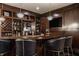 The home bar features open wood shelves with glass and liquor storage and seating for three at 1820 N 1100 E, Sheridan, IN 46069