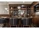 Fully stocked in-home bar features a mirror, wooden shelves, open storage and seating for three at 1820 N 1100 E, Sheridan, IN 46069
