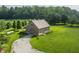 A beautiful grey barn with stone accents and a weathered grey roof sits on a lush lawn, accessible by a winding stone path at 1820 N 1100 E, Sheridan, IN 46069