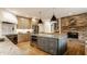 Open kitchen featuring a stone fireplace, a center island with seating, and stainless steel appliances at 1820 N 1100 E, Sheridan, IN 46069