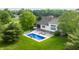 An aerial view of a stunning in-ground pool with modern lounge chairs and manicured landscaping surrounded by green grass at 1820 N 1100 E, Sheridan, IN 46069