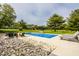 Backyard pool featuring surrounding lounge furniture and a small stone waterfall feature with a slide and playground at 1820 N 1100 E, Sheridan, IN 46069