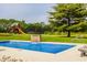 Beautiful in-ground pool with a small stone waterfall feature, a slide and playground equipment at 1820 N 1100 E, Sheridan, IN 46069