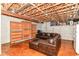 Basement featuring exposed beams, concrete walls, a large leather sofa, and built-in bookcases at 18967 Mill Grove Dr, Noblesville, IN 46062
