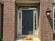 Elegant front door with sidelights, transom window, and brick surround at 18967 Mill Grove Dr, Noblesville, IN 46062