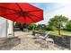 Outdoor patio area with stone pavers, featuring a red umbrella and outdoor furniture at 18967 Mill Grove Dr, Noblesville, IN 46062