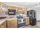 Efficient kitchen featuring oak cabinetry, a matching appliance package, and durable laminate flooring at 20530 Victory Chapel Rd, Noblesville, IN 46060