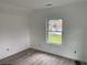 Sunlit bedroom with hardwood floors and a window overlooking the yard, awaiting personalization at 243 Iowa St, Indianapolis, IN 46225