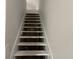 View of stairs needing rehab that connect the levels of the home with neutral walls at 243 Iowa St, Indianapolis, IN 46225