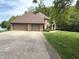 A large, brick house with a three-car garage sits at the end of a concrete driveway next to a lake at 2925 N Country Club Rd, Martinsville, IN 46151