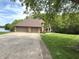 A large, brick house with a three-car garage sits at the end of a concrete driveway next to a lake at 2925 N Country Club Rd, Martinsville, IN 46151