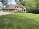 A brick two-story house with an attached garage sits on a large, well-manicured lawn surrounded by mature trees at 2925 N Country Club Rd, Martinsville, IN 46151