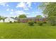 Well-kept backyard featuring bushes and lush green grass surrounding this charming home at 30 N Depot St, New Palestine, IN 46163