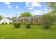 Well-kept backyard featuring bushes and lush green grass surrounding this charming home at 30 N Depot St, New Palestine, IN 46163